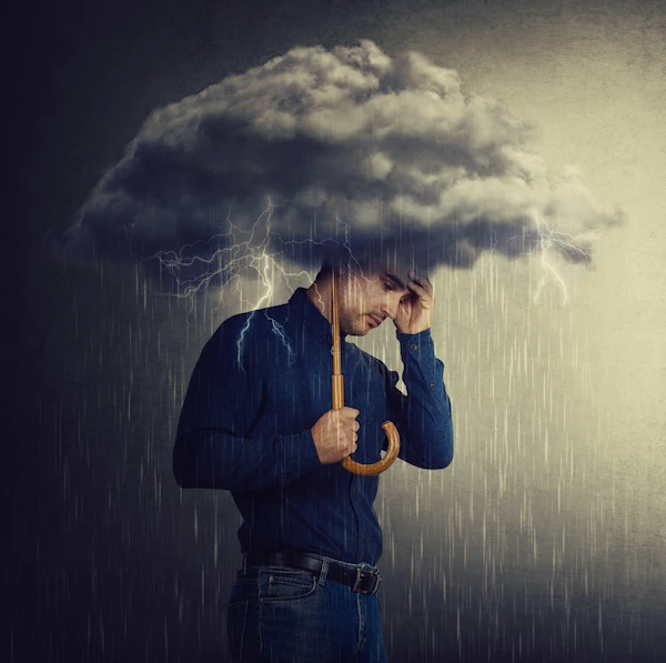 man under an umbrella cloud of despair